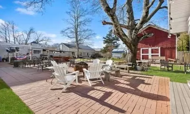 Wooden terrace with an outdoor structure and an outdoor fire pit