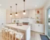 Kitchen featuring pendant lighting, a kitchen island with sink, sink, light hardwood / wood-style flooring, and light brown cabinetry