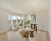 Living room featuring a high ceiling, a glass covered fireplace, visible vents, and recessed lighting