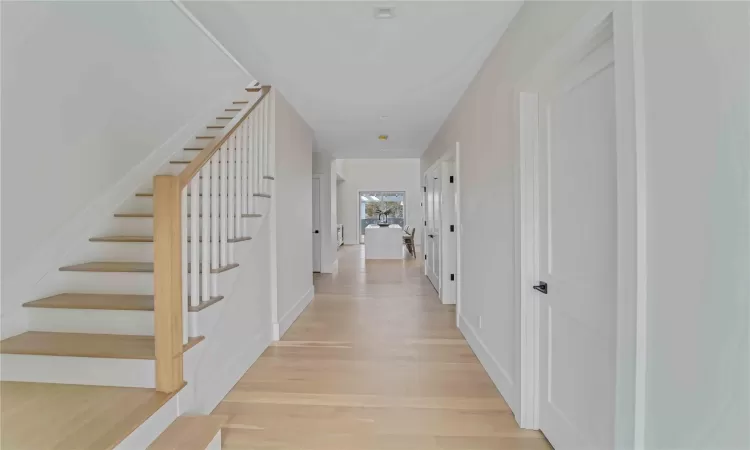 Hall with light wood-style flooring and stairs