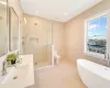 Full bathroom with vanity, tile patterned floors, separate shower and tub, toilet, and tile walls