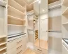 Walk in closet with hardwood / wood-style floors