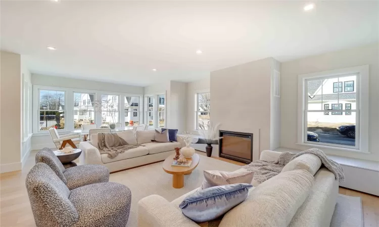 Living room with a fireplace and light hardwood / wood-style floors