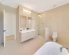 Full bathroom featuring tile patterned flooring, vanity, toilet, and tile walls