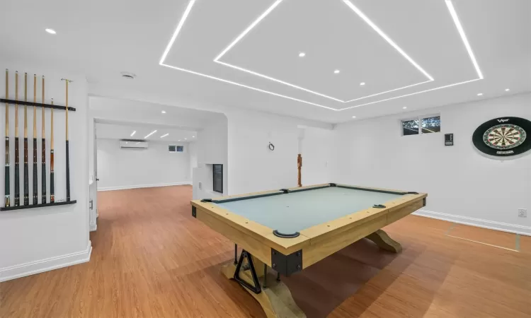 Playroom featuring a wall unit AC, hardwood / wood-style floors, and billiards