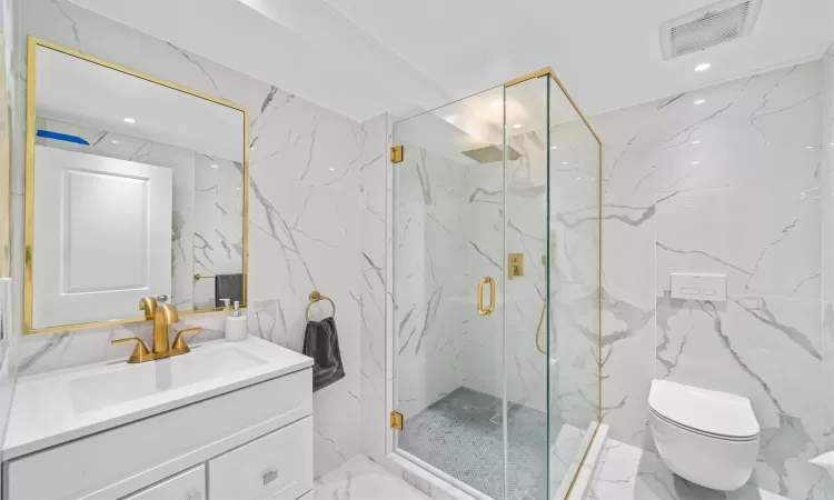 Bathroom with vanity, an enclosed shower, tile walls, and toilet