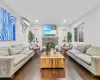 Living room featuring a wall mounted AC, crown molding, a stone fireplace