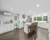 Kitchen featuring white cabinetry, wall chimney exhaust hood, stainless steel appliances