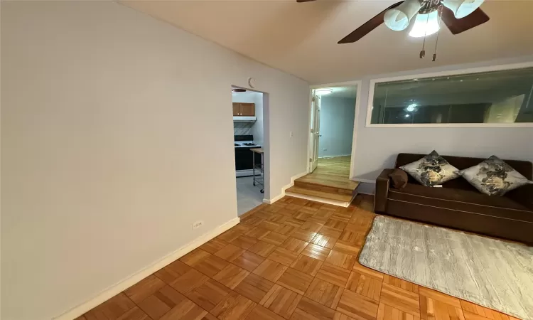 Living room featuring ceiling fan and parquet floors