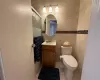 Bathroom with tile patterned flooring, vanity, toilet, and tile walls