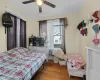 Bedroom with hardwood / wood-style floors, ceiling fan, and ornamental molding