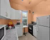 Kitchen featuring white cabinets, white appliances, ceiling fan, and sink