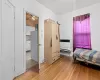 Bedroom featuring white fridge, light hardwood / wood-style flooring, and heating unit