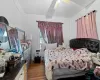 Bedroom with wood-type flooring, ceiling fan, and cooling unit