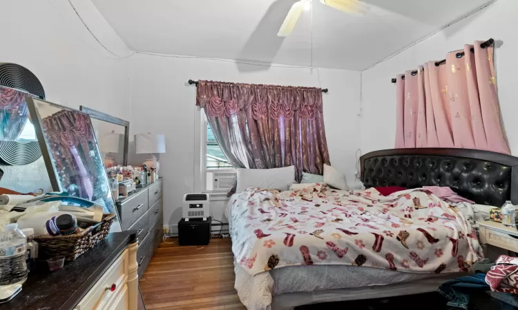 Bedroom with wood-type flooring, ceiling fan, and cooling unit