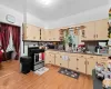 Kitchen featuring ornamental molding, stainless steel appliances, sink, cream cabinets, and light hardwood / wood-style flooring