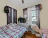 Bedroom with wood-type flooring, ceiling fan, and ornamental molding