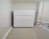 Kitchen with light tile patterned floors and white appliances