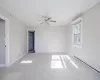 Spare room featuring light carpet, crown molding, ceiling fan, and a baseboard heating unit