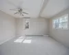 Carpeted empty room featuring ceiling fan, lofted ceiling with beams, crown molding, and a baseboard radiator