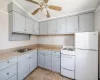 Kitchen featuring white appliances, ceiling fan, crown molding, and sink