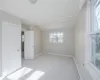 Unfurnished bedroom with light carpet, multiple windows, and ornamental molding