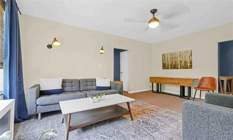 Living room featuring carpet flooring and ceiling fan