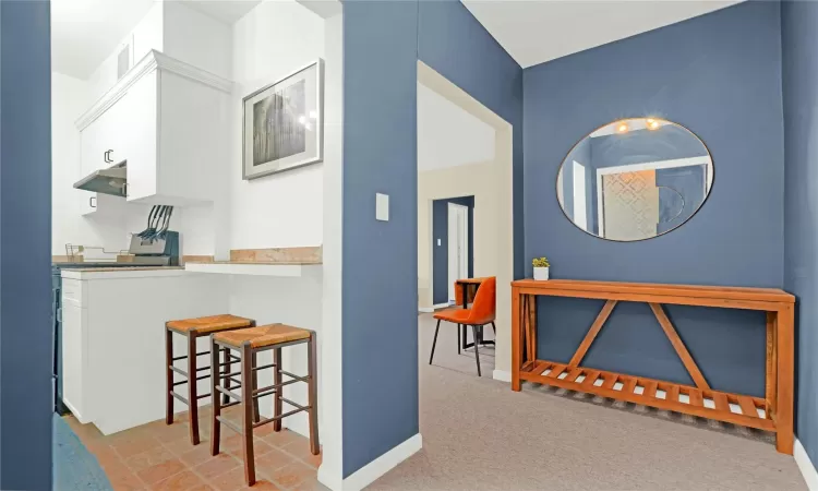 Hallway featuring light colored carpet