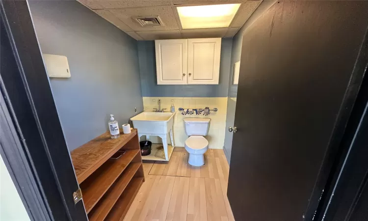 Bathroom with tile patterned floors, a paneled ceiling, and toilet