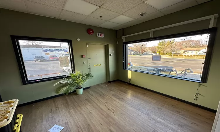 Unfurnished room featuring hardwood -style flooring and a drop ceiling