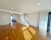 Unfurnished living room with wood-type flooring and a notable chandelier