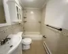 Full bathroom featuring tile patterned floors, crown molding, baseboard heating, and tile walls