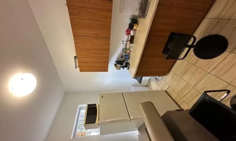 Kitchen with sink, light tile patterned floors, and fridge