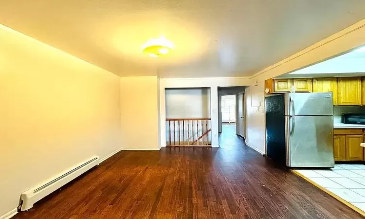 Kitchen featuring stainless steel fridge, a baseboard heating unit, and hardwood / wood-style floors