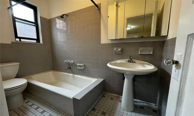 Bathroom featuring tile patterned flooring and tile walls