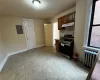 Kitchen featuring backsplash, electric panel, stainless steel range with electric cooktop, and radiator