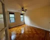 Empty room with ceiling fan and light parquet flooring