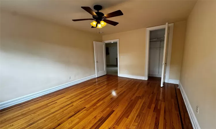 Unfurnished bedroom featuring ceiling fan, a closet, and dark wood-type flooring