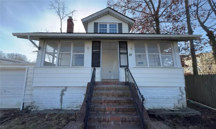 View of front of property with a garage and an outbuilding