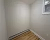 Empty room featuring hardwood / wood-style floors and a baseboard radiator