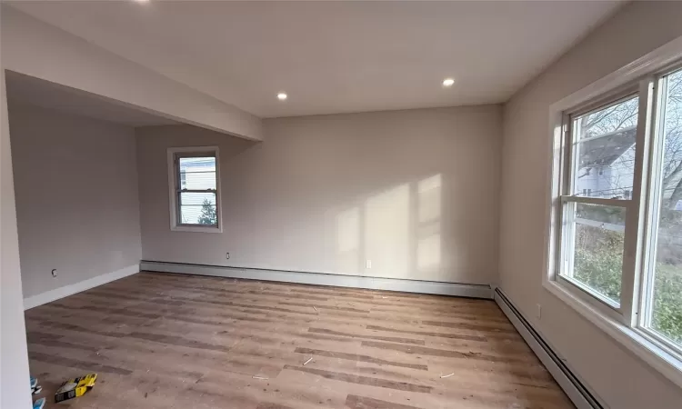 Spare room featuring light wood-type flooring and baseboard heating