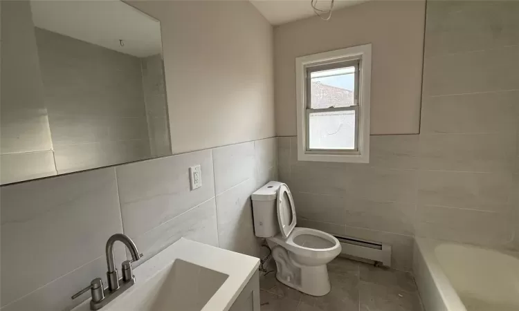 Bathroom featuring baseboard heating, tile patterned flooring, tile walls, and toilet