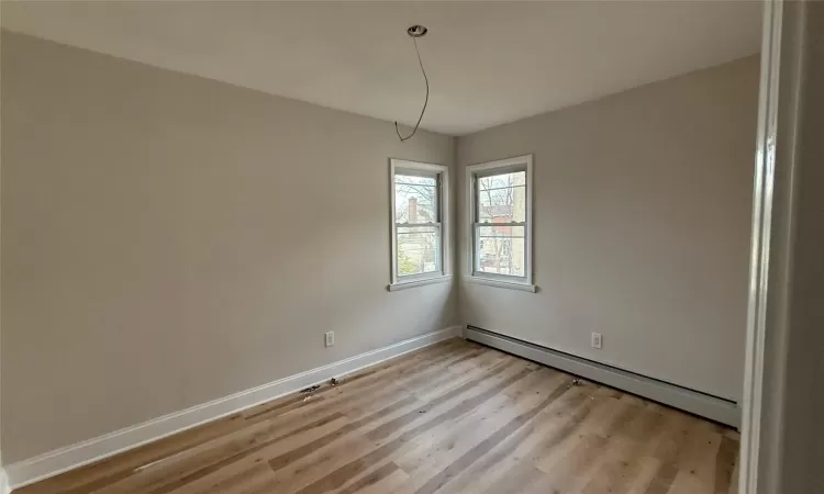 Unfurnished room featuring light hardwood / wood-style flooring and baseboard heating