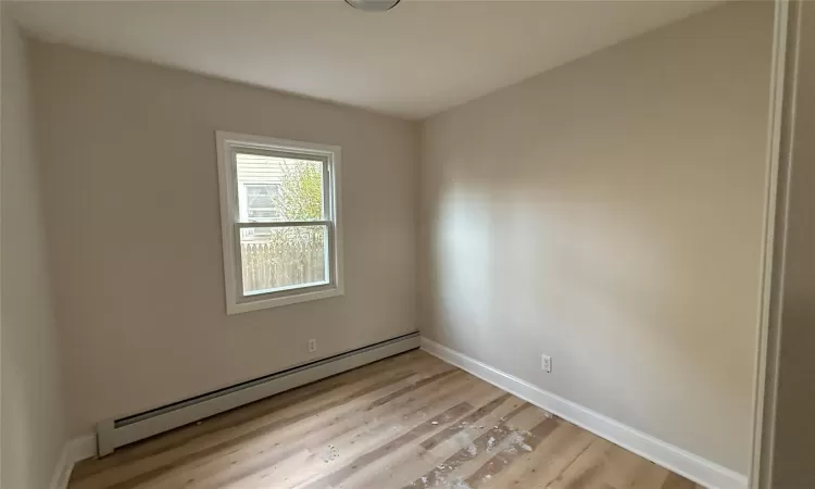 Unfurnished room featuring light hardwood / wood-style floors and baseboard heating