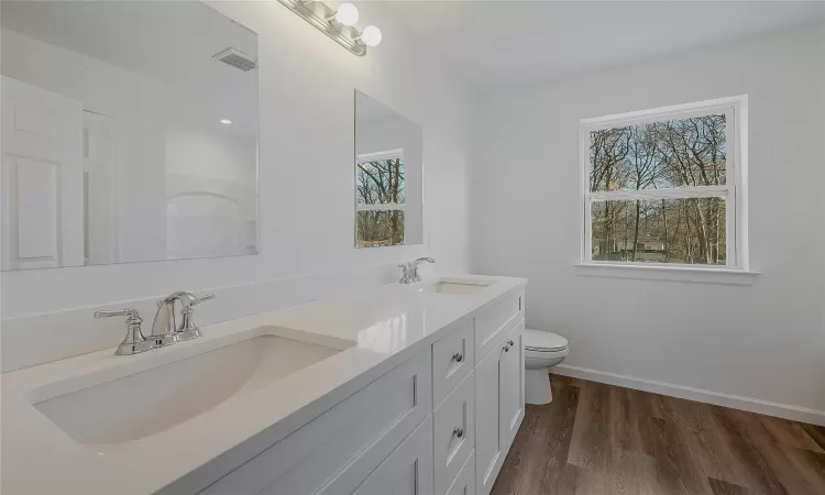 Full bathroom located in the primary bedroom with double sinks, closet & tub.