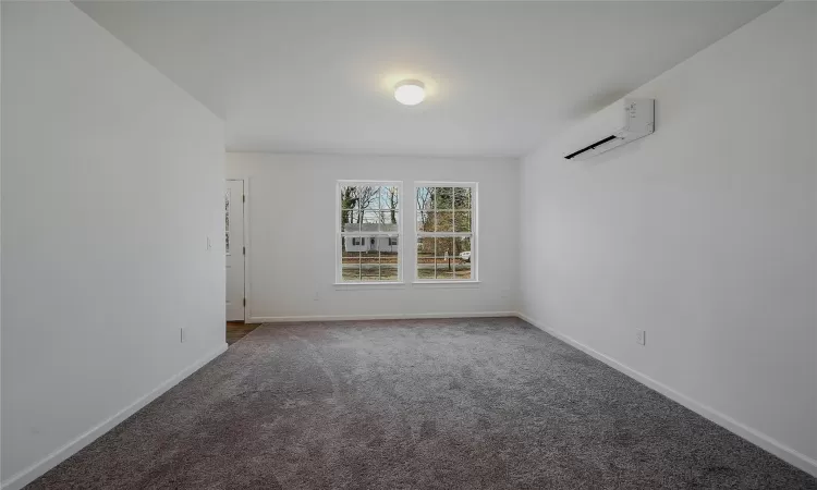 Formal dining room with neutral color carpets & mini split for heating & cooling.