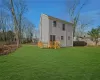 Rear view of house featuring a lawn and a wooden deck, grass is photoshopped.