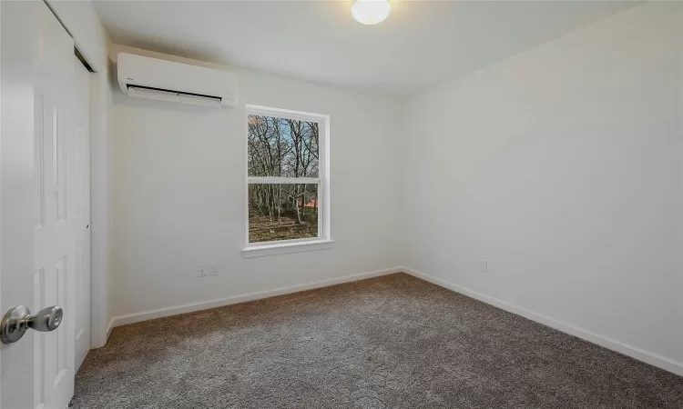 Second Bedroom with neutral color carpet & mimi split for heating & cooling.