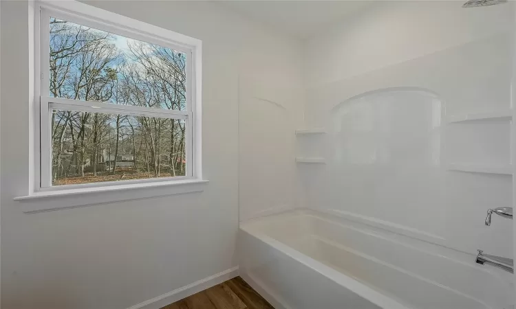 Tub located in primary bedrooms bathroom.