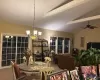 dining space with ceiling fan with notable chandelier and cathedral ceiling